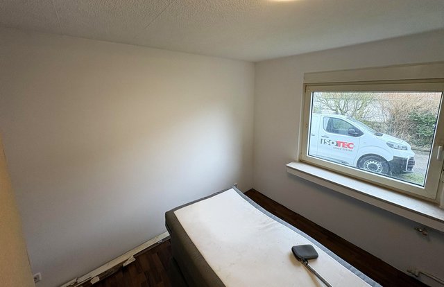 Zimmer mit Fensterbank; draußen steht ein ISOTEC Transporter.