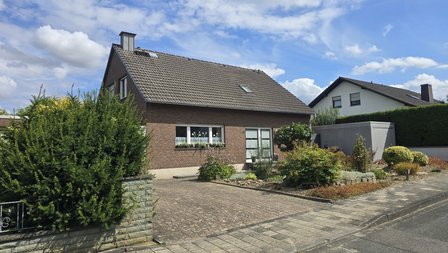 Hausansicht mit Auffahrt und schönem blauen Himmel