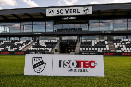 ISOTEC Werbeschild auf Rasen vor Stadiontribuene mit SC VERL Schriftzug