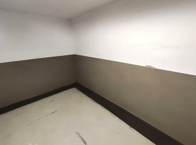 Verfärbte Zimmerecke mit dunklen Flecken am oberen Wand- und Deckenanschluss