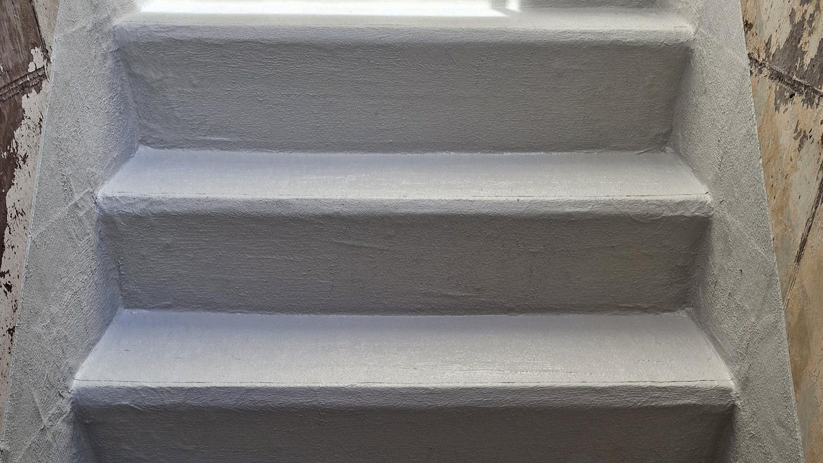 Graue beschichtete Treppe in engem Treppenhaus, Frontalansicht