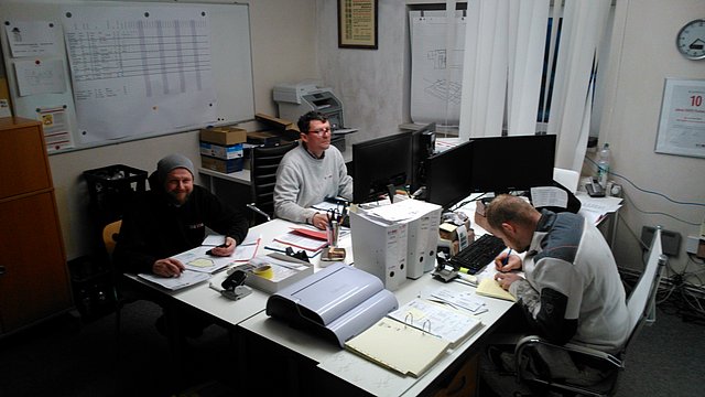 Team ISOTEC-Pläsken Bauleiter und zwei Monteure bei Arbeiten der anderen Art im Büro am Computer
