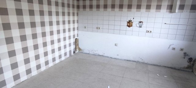 Leerer Raum mit karierten Wänden und verschmutztem Wandbereich