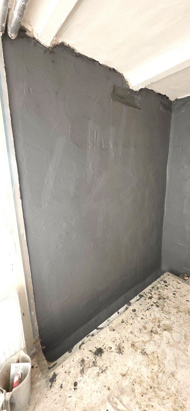 Schwarze Masse auf Kellerwand aufgetragen, Nahaufnahme