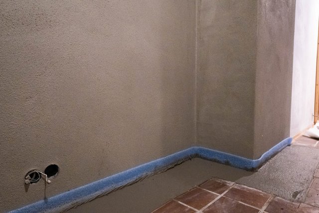 Verputzte Kellerwand mit Kabelauslass und abgedecktem Boden