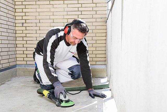 ISOTEC Mitarbeiter schleift Boden mit elektrischem Gerät