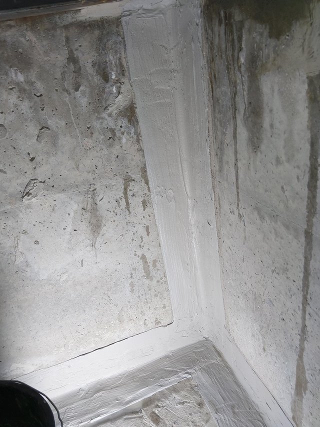 Helle Masse an Kellerwandecke und Bodenanschluss, Nahaufnahme