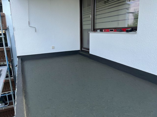 Schwarzer Bodenbelag auf Balkon, Werkzeuge auf Fensterbank