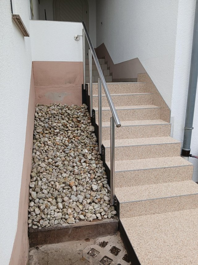 Hauseingang mit Steintreppe, Edelstahlgeländer und Kiesfläche