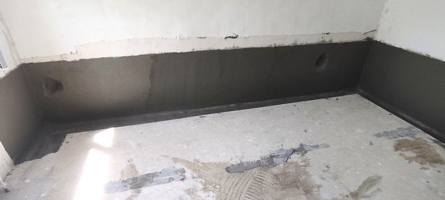 Dunkle Masse auf unterem Wandbereich eines Zimmers