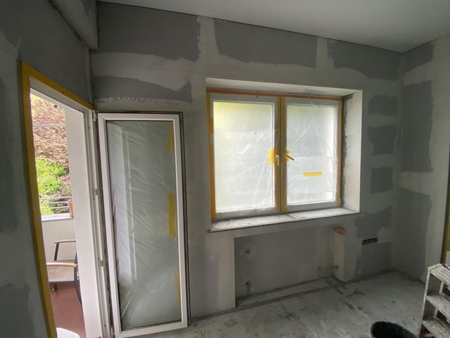 Raum mit gespachtelten Trockenbauwänden, abgeklebt an Fenster und Balkontür