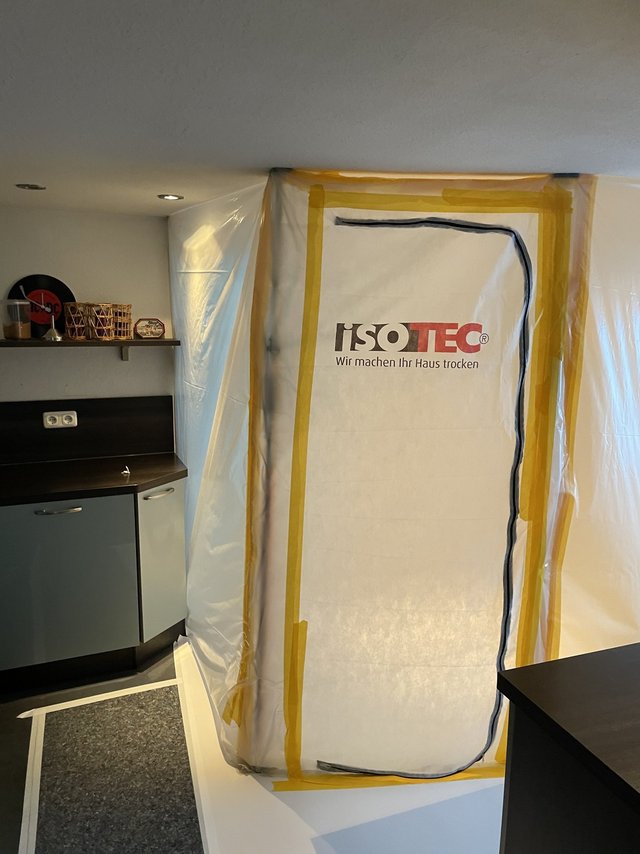 Wand mit transparenter Folie und gelbem Klebeband abgedeckt, ISOTEC Schriftzug auf der Folie