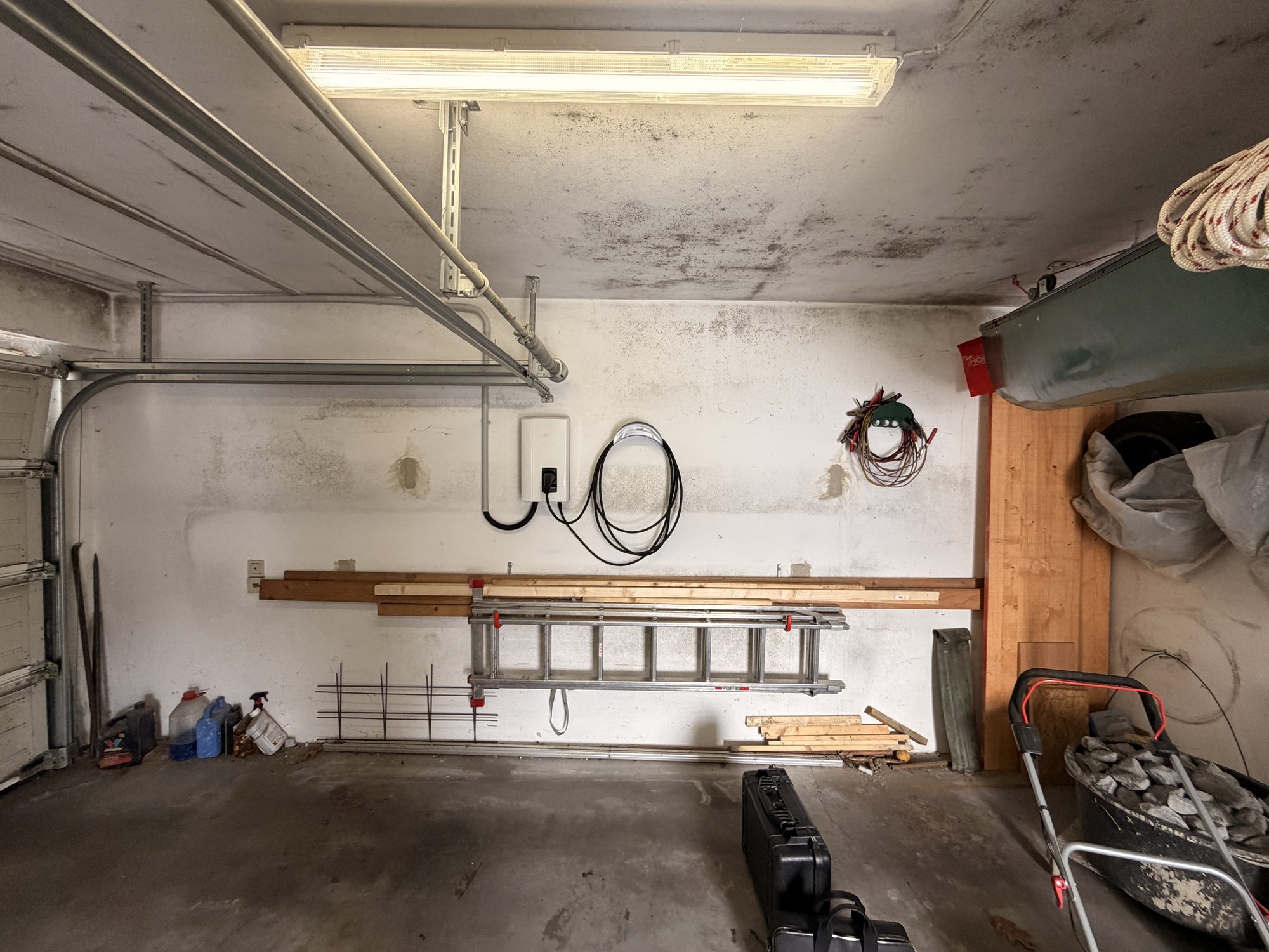 Schimmelspuren an Garagendecke und Wand, Werkzeuge und Holz gelagert