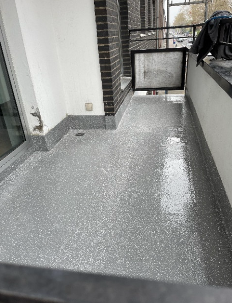 Grauer Balkonboden mit frischer Beschichtung, Blick entlang des Balkons