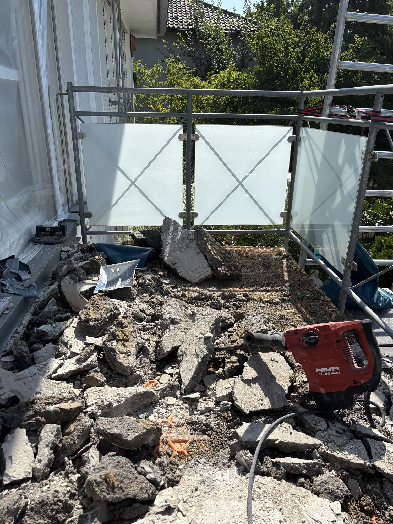 Aufgestemmter Balkon mit Betonschutt und Bohrhammer