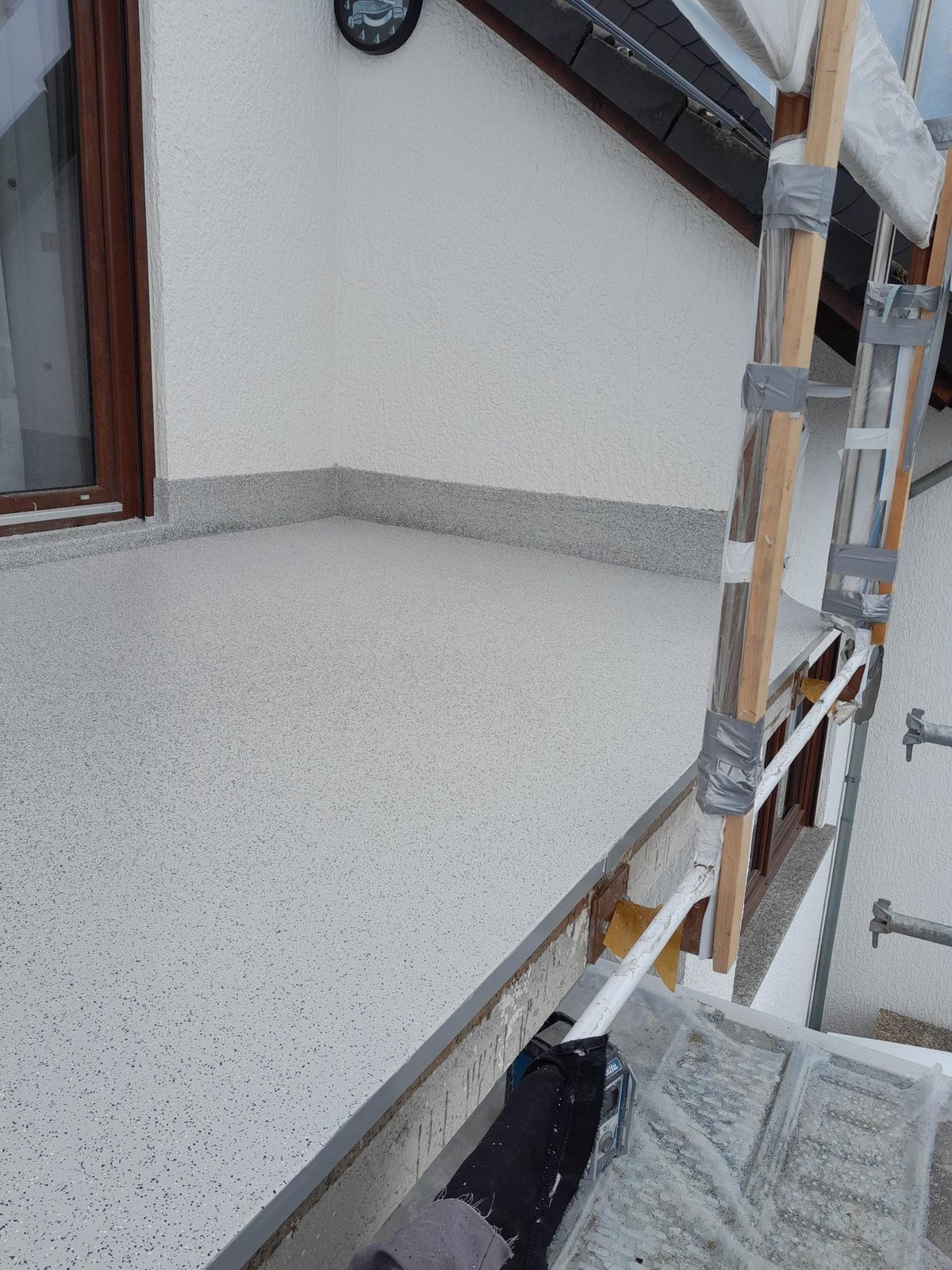 Frisch beschichteter Balkonboden mit hellgrauer, fein gesprenkelter Oberfläche