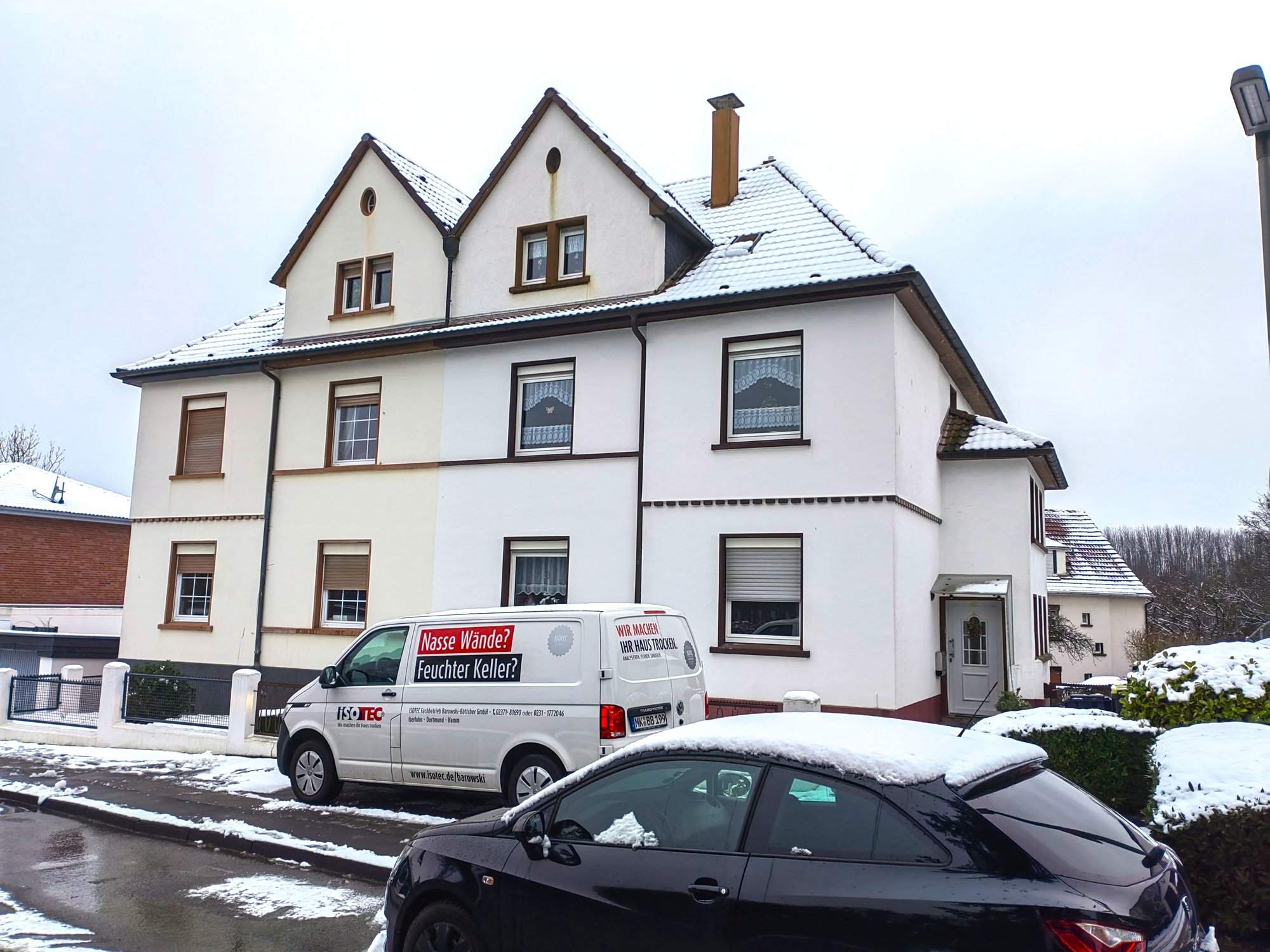 ISOTEC Fahrzeug vor Wohnhaus mit schneebedecktem Dach
