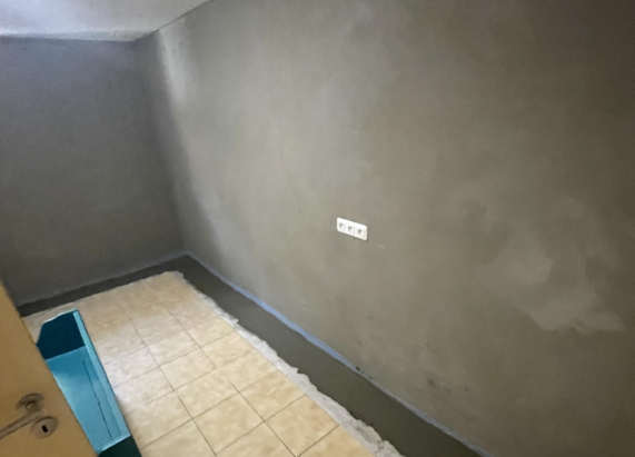 Leerer Raum mit grauer Wandbeschichtung und gefliestem Boden