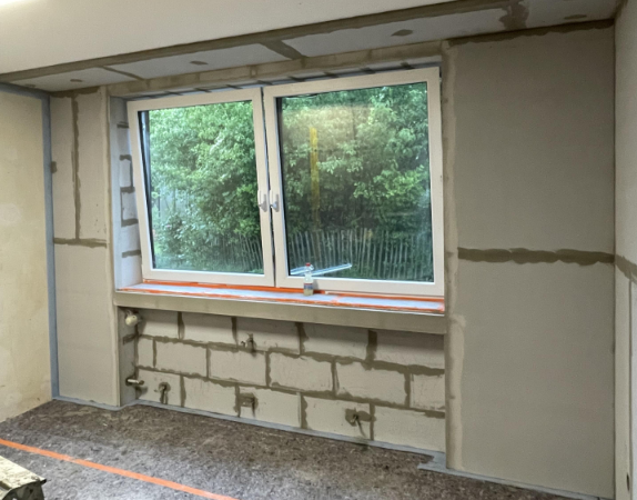 Großes Fenster in renoviertem Zimmer, graue Masse an Fugen und Kanten