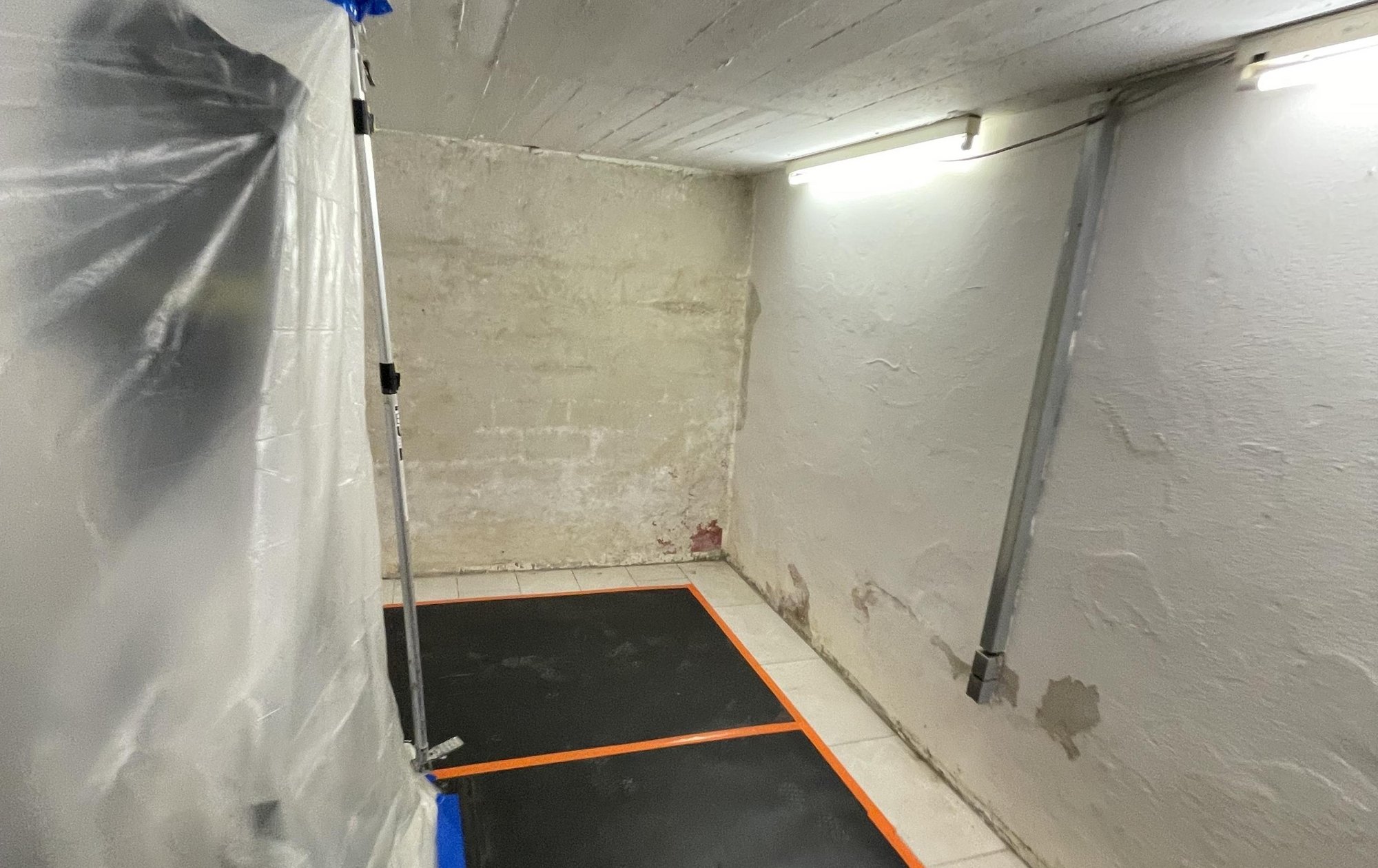 Feuchte Kellerwaende mit Abplatzungen und abgehaengter Schutzfolie