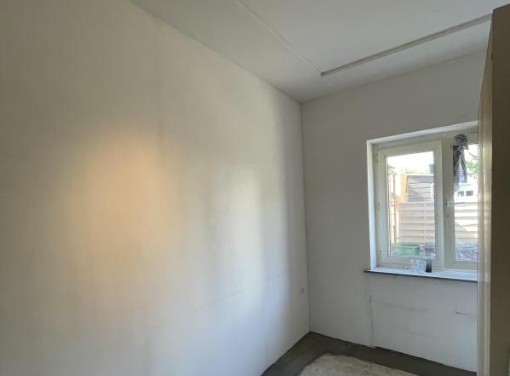 Leerer Raum mit weißer Wand, Fenster und rohem grauen Boden, Blick in eine Ecke