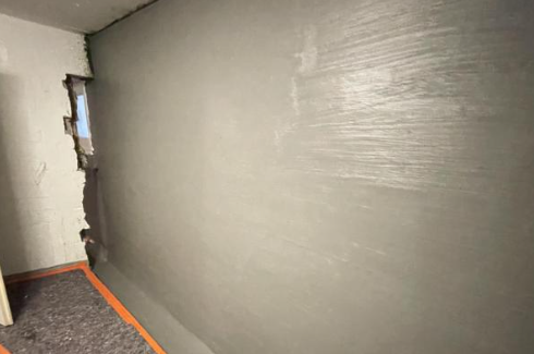 Glatte graue Masse auf frisch bearbeiteter Wand