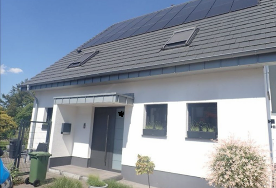 Einfamilienhaus mit Solarmodulen auf dem Dach und zwei Dachfenstern