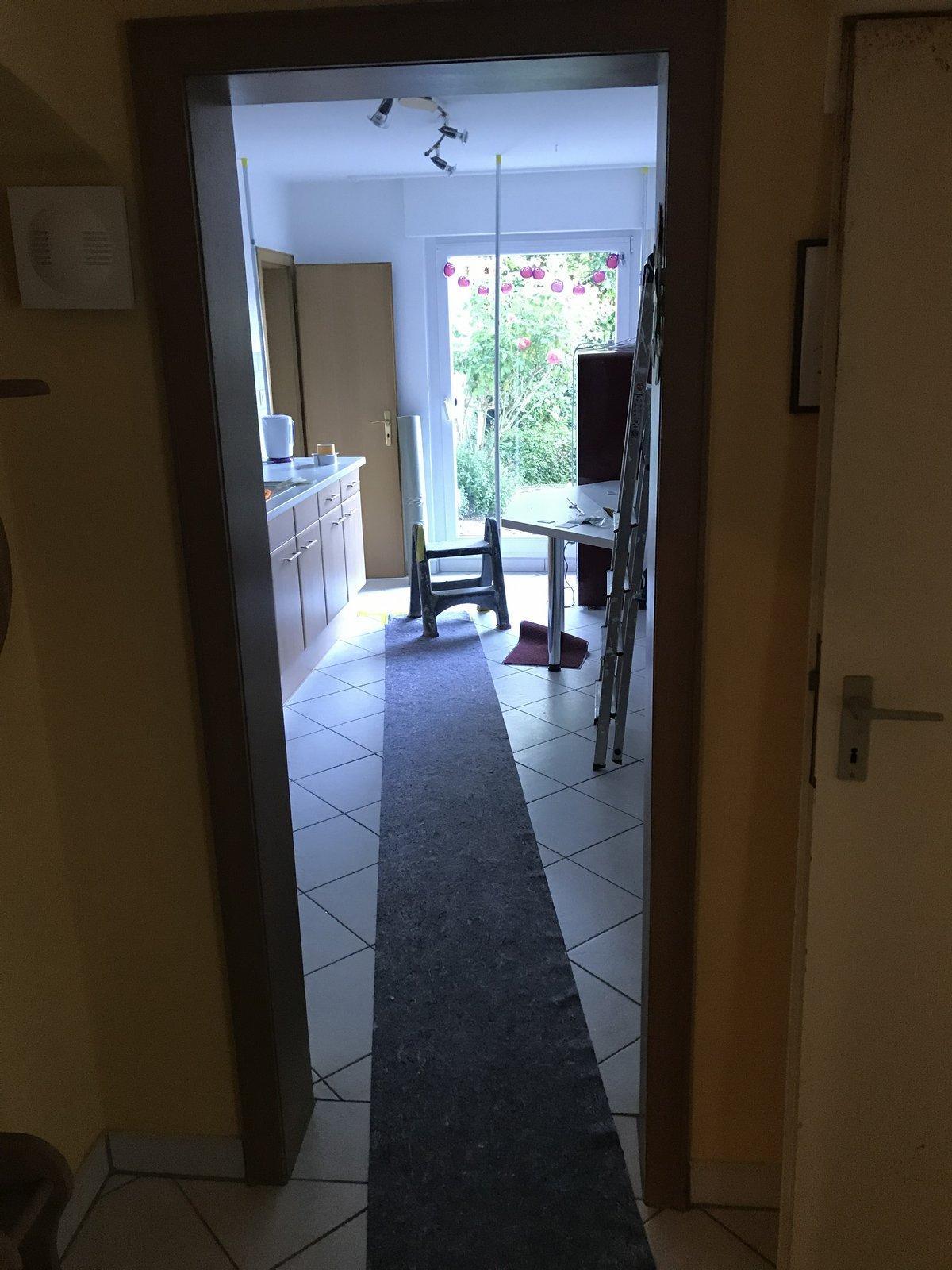 Blick durch die Tür in die helle Küche- Laufwege sind abgedeckt