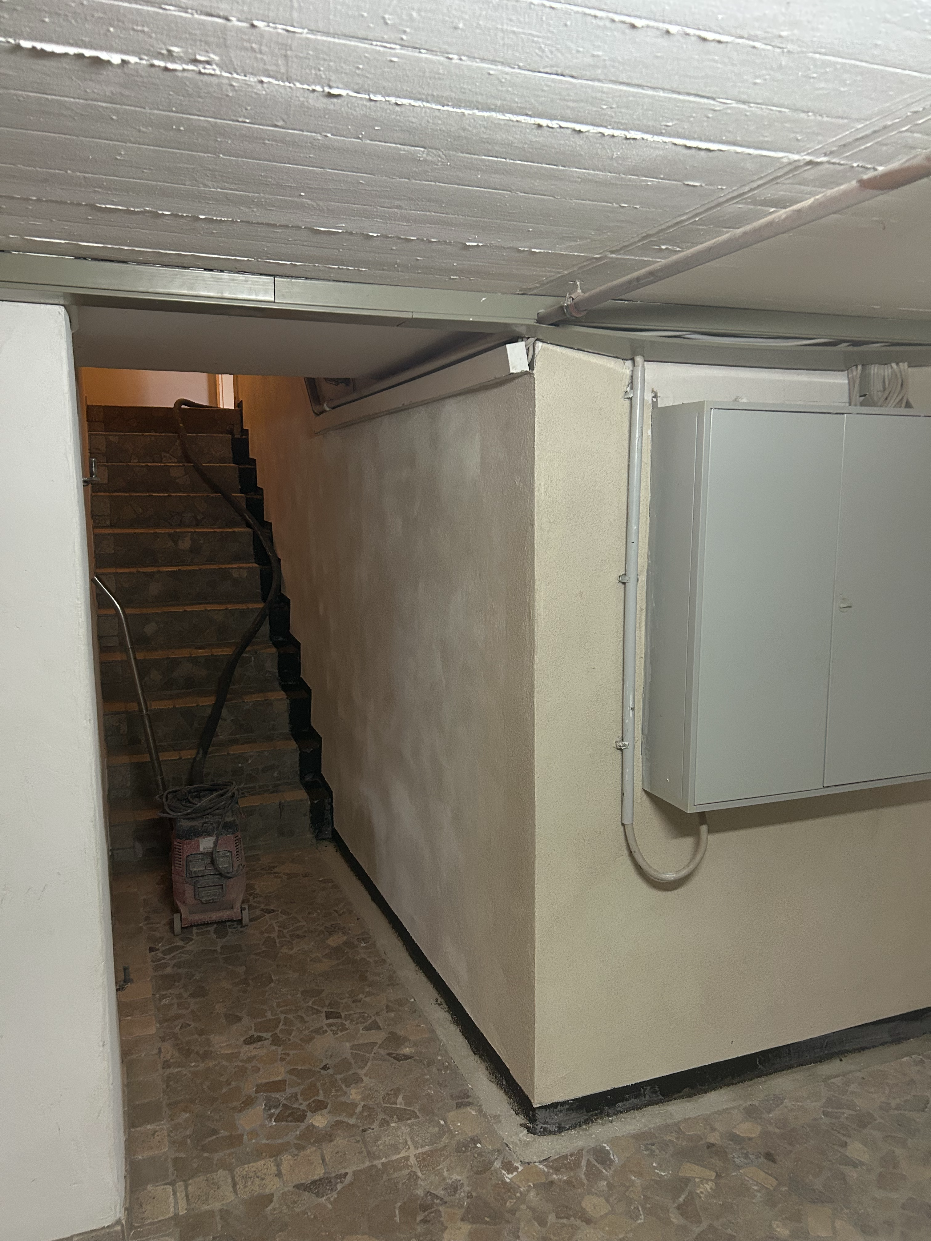 Kellerflur mit Treppe im Bereich des Sicherungskastens nach Auftrag des Schutzputzes in neuem Glanz