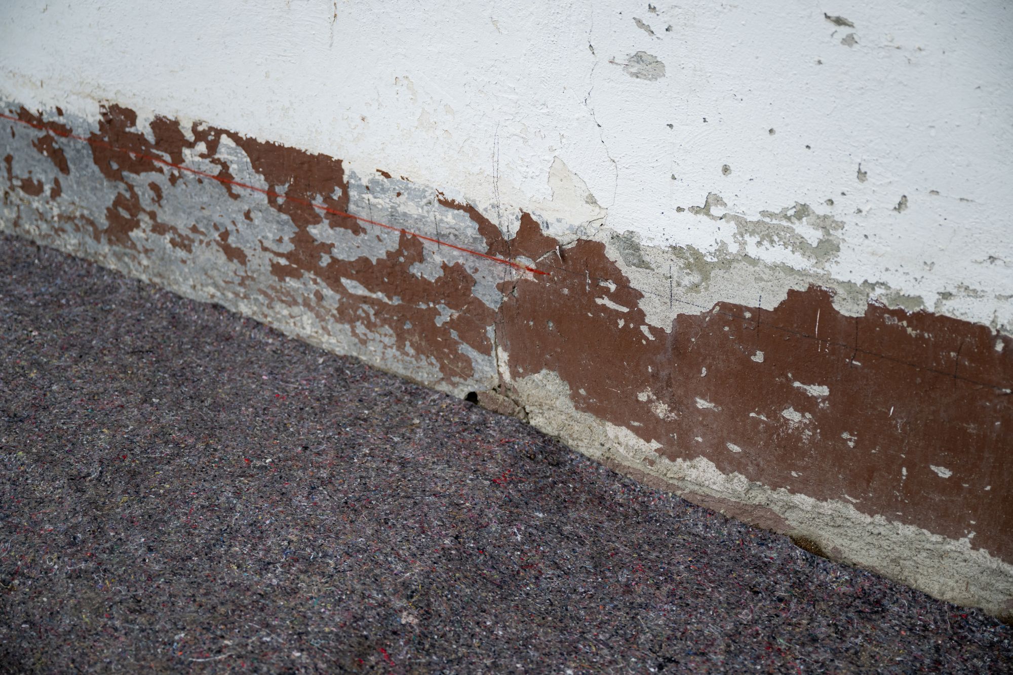 Deutliche Feuchtigkeitsschäden am äußeren Sockel des Hauses