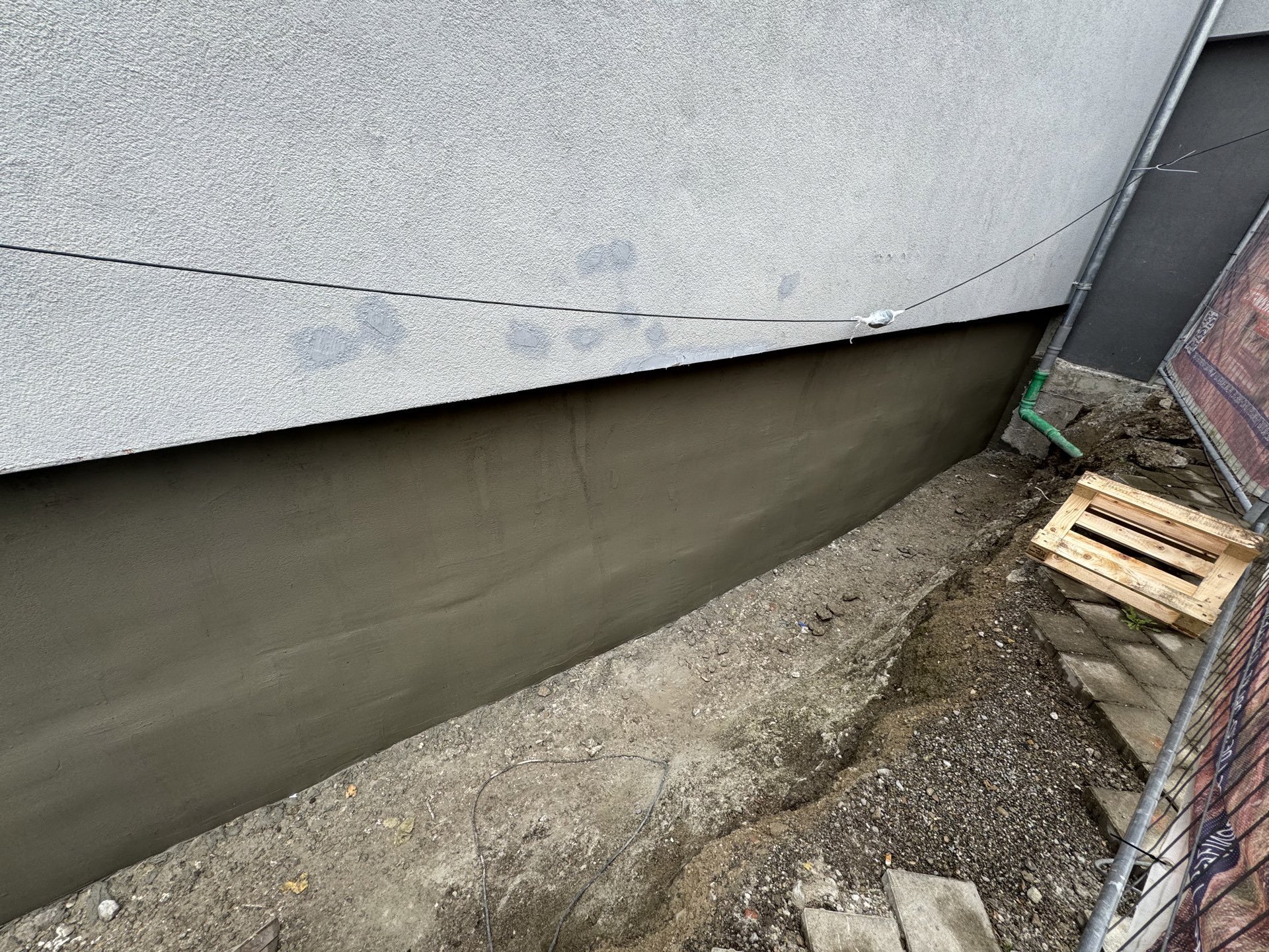 Glatt verstrichene graue Masse auf freigelegter Kellerwand