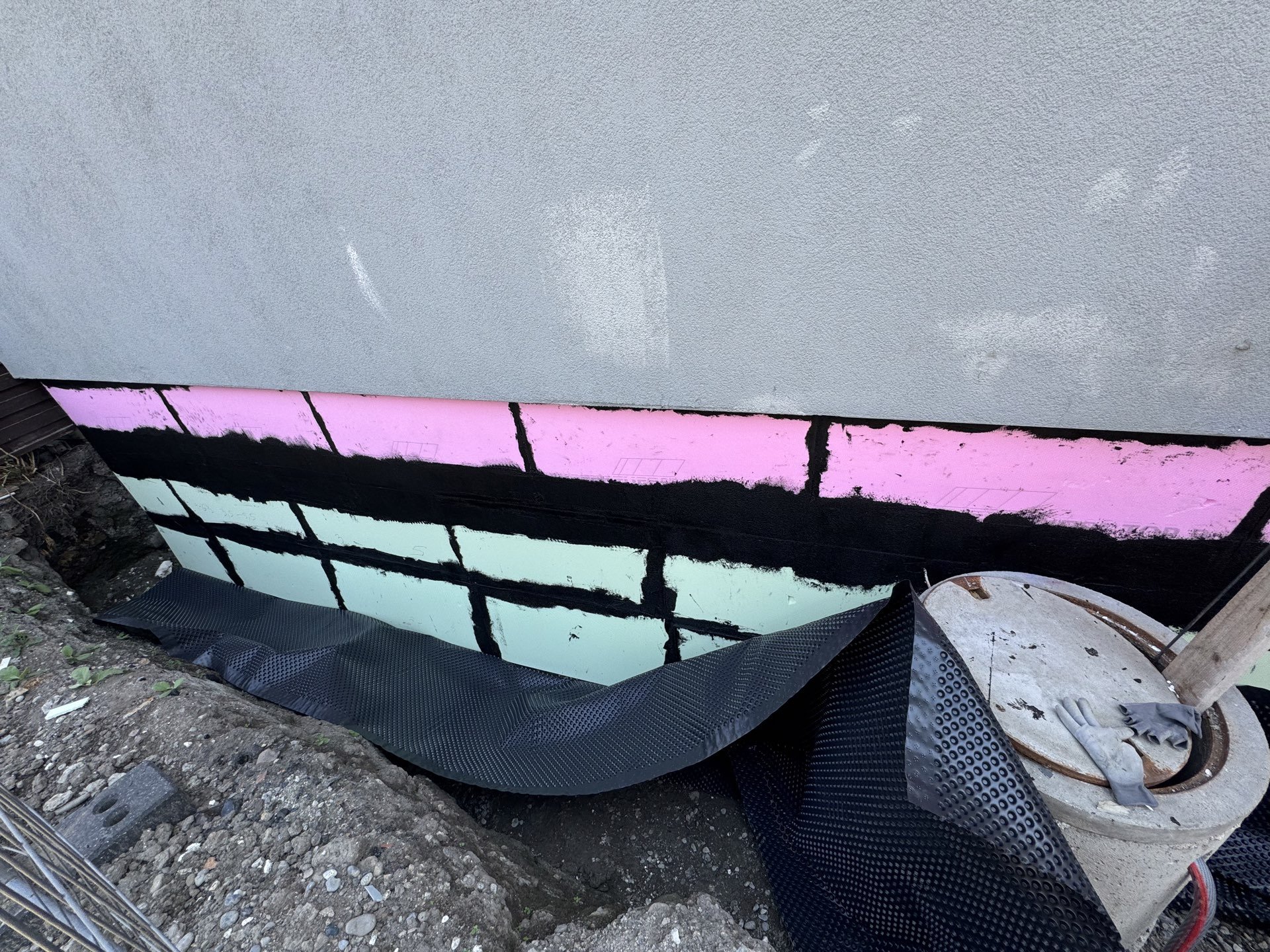 Beschichtete Dämmplatten am freigelegten Gebäudesockel