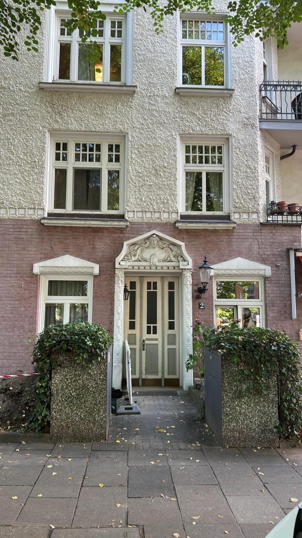 Hauseingang mit verzierter Tür, Backsteinfassade und Fenstern, Straßenansicht